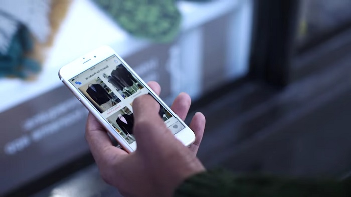 Close up shot of a man's hand checking his smartphone for online cloth purchasing.