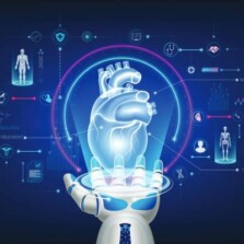 Image of a robotic hand holding a hologram of a human heart and icons related to futuristic medical cybernetics and robotics technology shown around it on a deep blue background.